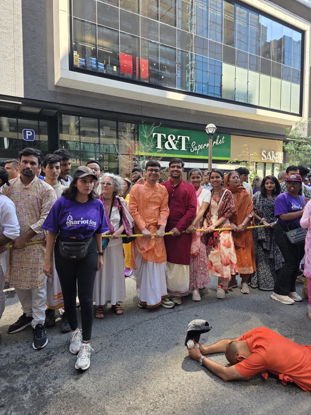Devotees pulling the rope as one offers obeisances on the road